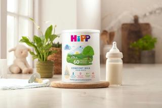 HiPP comfort milk powder tin next to a bottle of milk on a kitchen worktop