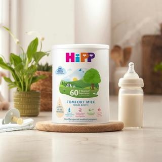 HiPP Organic comfort milk powder tin next to a milk bottle on a kitchen worktop