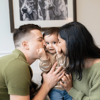 Parents kissing son's cheeks