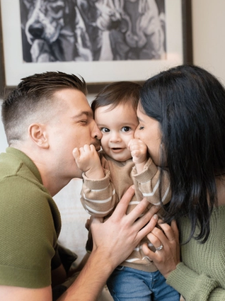 Parents kissing son's cheeks