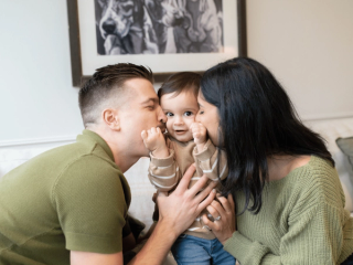 Parents kissing son's cheeks