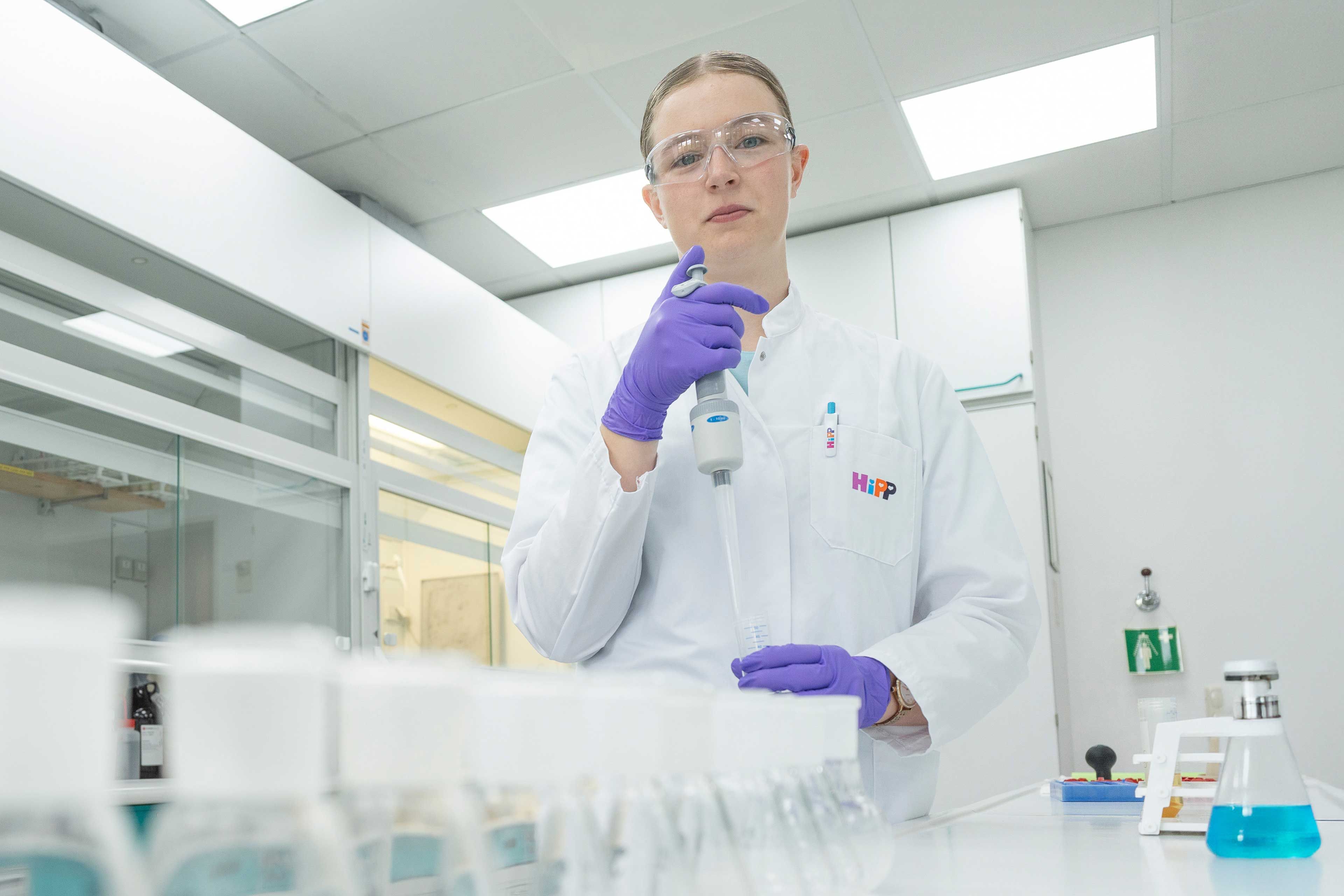 Milchwirtschaftliche Laborantin im HiPP-Labor pipettiert Proben zur Qualitätskontrolle von Milchprodukten und Babynahrung.