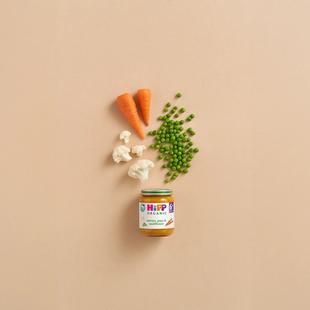HiPP Organic Carrots, Peas & Cauliflower baby food jar with fresh carrots, peas and cauliflower on a neutral background