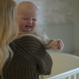 Baby crying over mums shoulder