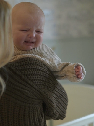 Baby crying over mums shoulder
