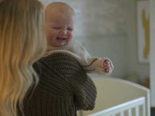 Baby crying over mums shoulder