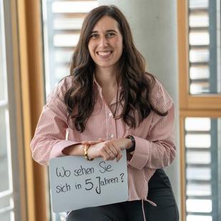 HiPP Mitarbeiterin hält ein Schild mit der Aufschrift 'Wo sehen Sie sich in 5 Jahren'
