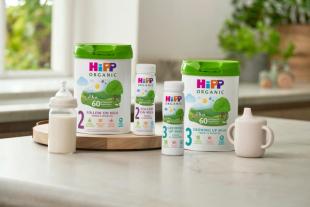 HiPP follow on and growing up milks next to milk bottle and beaker
