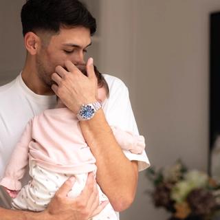 Parent gently cuddling a young baby on their shoulder, offering comfort during colic or constipation discomfort.