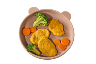 Kinderteller mit drei Nuggets, Brokkoliröschen und Karottenscheiben in einem Teller mit Bärenohren