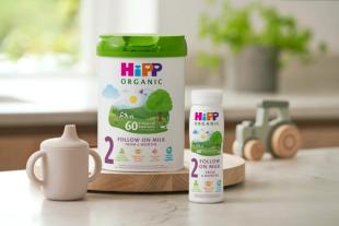 HiPP follow on milk range on a kitchen worktop next to a beaker