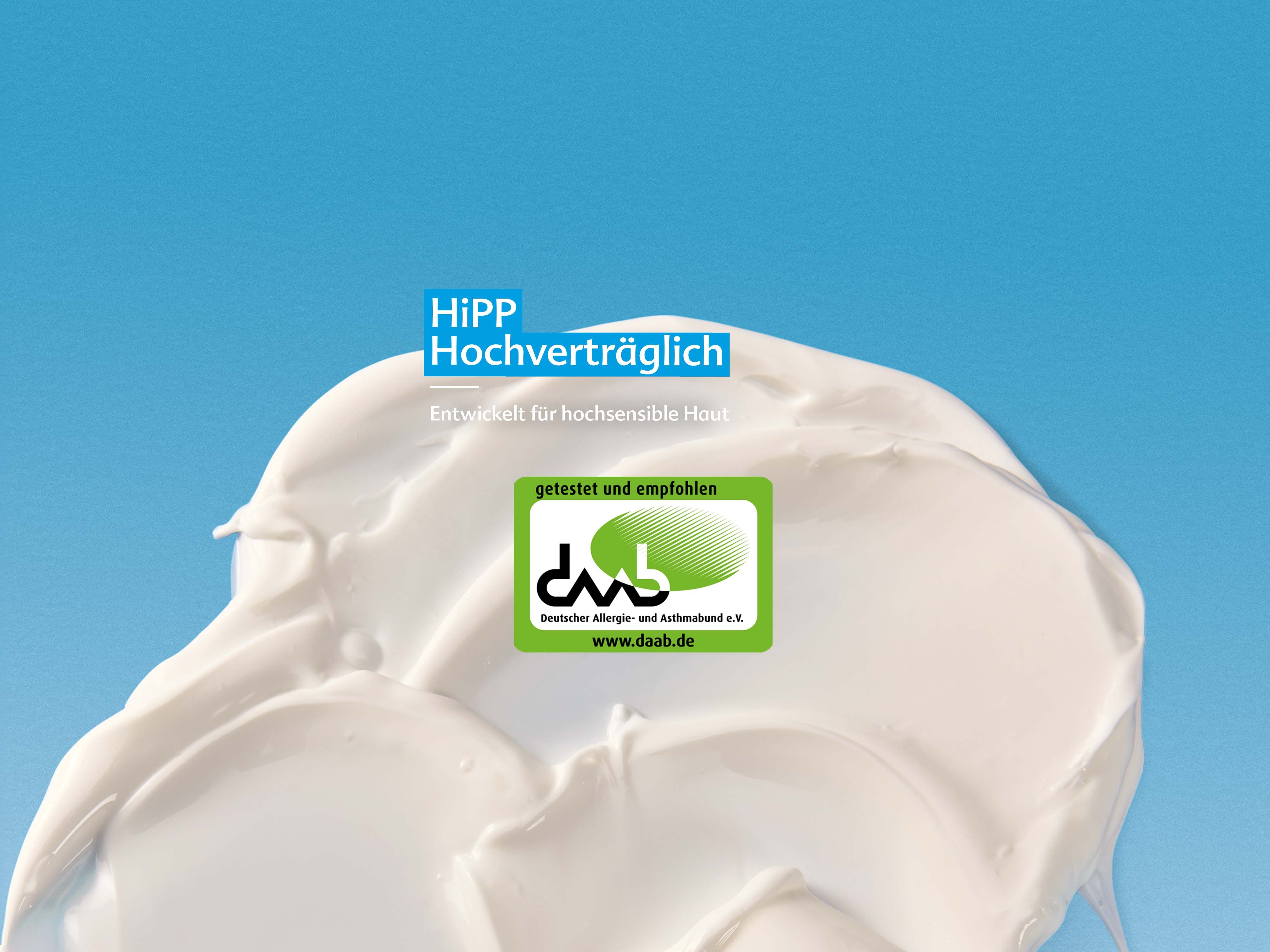 Nahaufnahme einer weißen Creme mit dem Text 'HiPP Hochverträglich' und einem grünen dm-Qualitätssiegel auf blauem Hintergrund