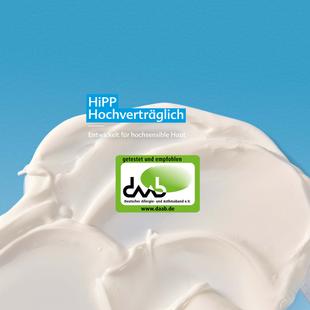 Nahaufnahme einer weißen Creme mit dem Text 'HiPP Hochverträglich' und einem grünen dm-Qualitätssiegel auf blauem Hintergrund