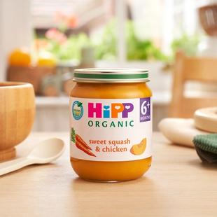 HiPP Organic Sweet Squash & Chicken on a dining table next to a bowl and spoon