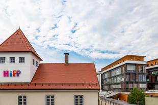 Foto des HiPP Geländes auf dem ein Büro und ein Haus im Vordergrund zu sehen sind