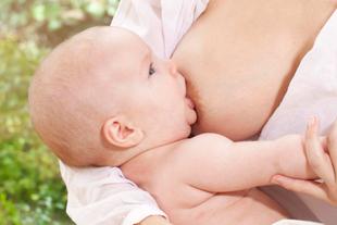 Baby wird an der Brust gestillt, nah aufgenommen, Symbol für nährstoffreiche und schützende Muttermilch