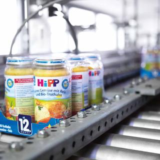 HiPP Bio-Gemüsegläschen auf einem Förderband in der Qualitätskontrolle im Werk