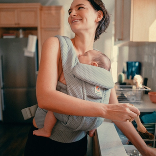 Mum babywearing whilst washing hands