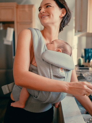 Mum babywearing whilst washing hands