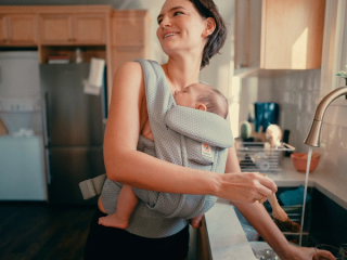 Mum babywearing whilst washing hands