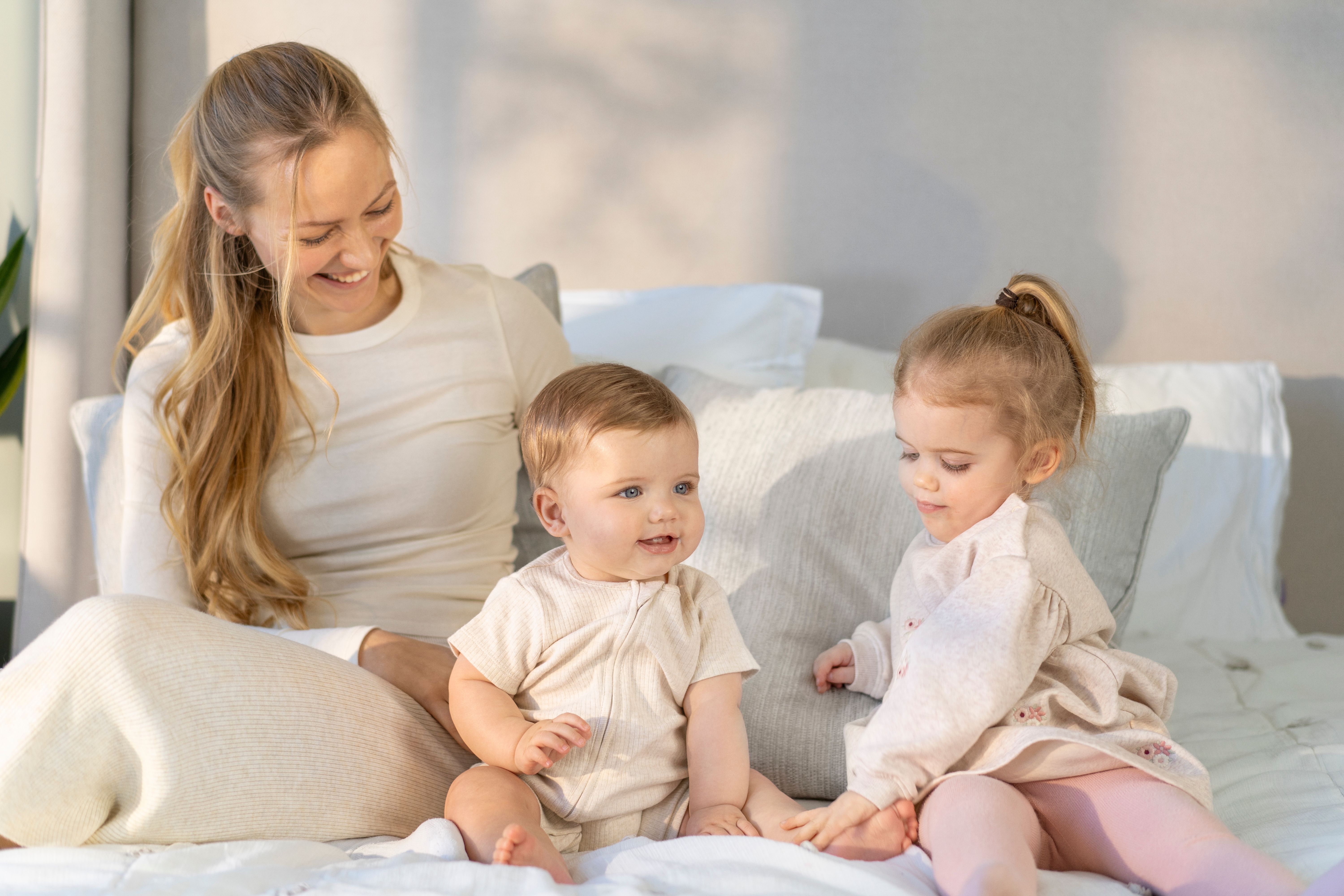 Mother cuddling her baby on a sofa in a living room