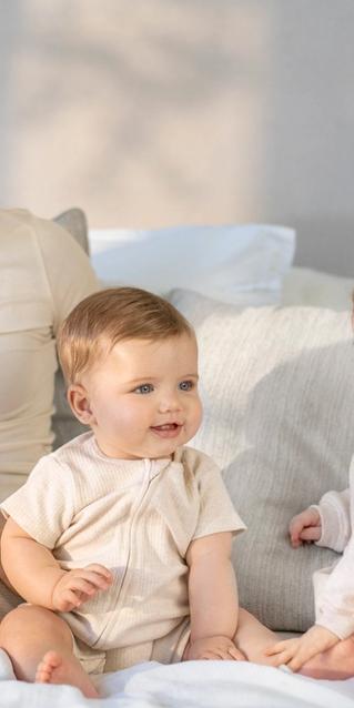 Mother cuddling her baby on a sofa in a living room