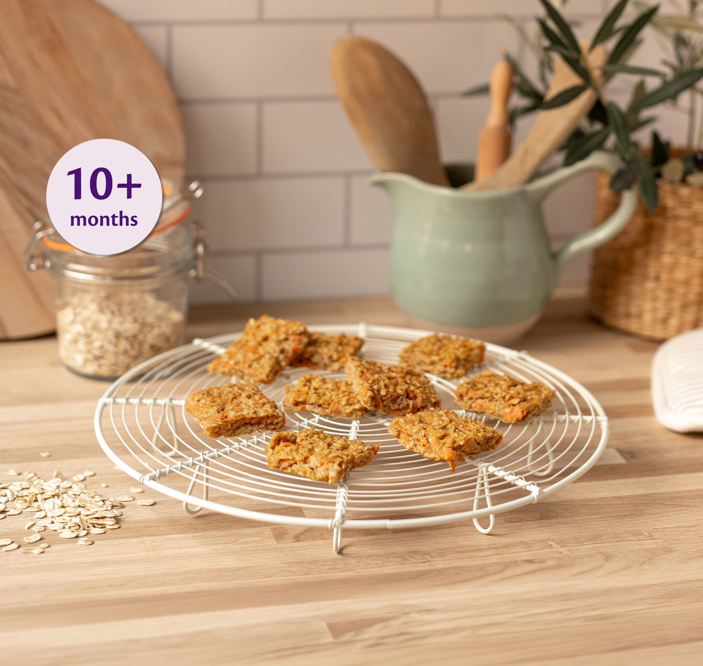 Carrot and apple breakfast squares cooling on a wire rack in a cosy kitchen, labelled suitable for babies 10+ months