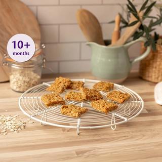 Carrot and apple breakfast squares cooling on a wire rack in a cosy kitchen, labelled suitable for babies 10+ months