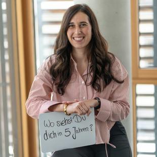 HiPP Mitarbeiterin hält ein Schild mit 'Wo siehst Du dich in 5 Jahren?'