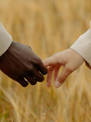 Man and woman holding hands in a field