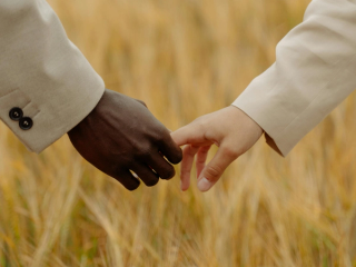 Man and woman holding hands in a field
