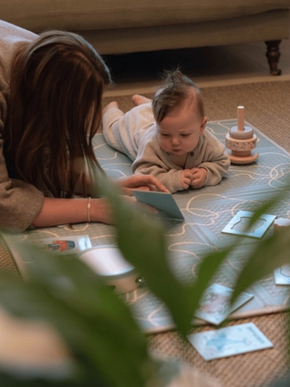 Mum reading development cards to baby