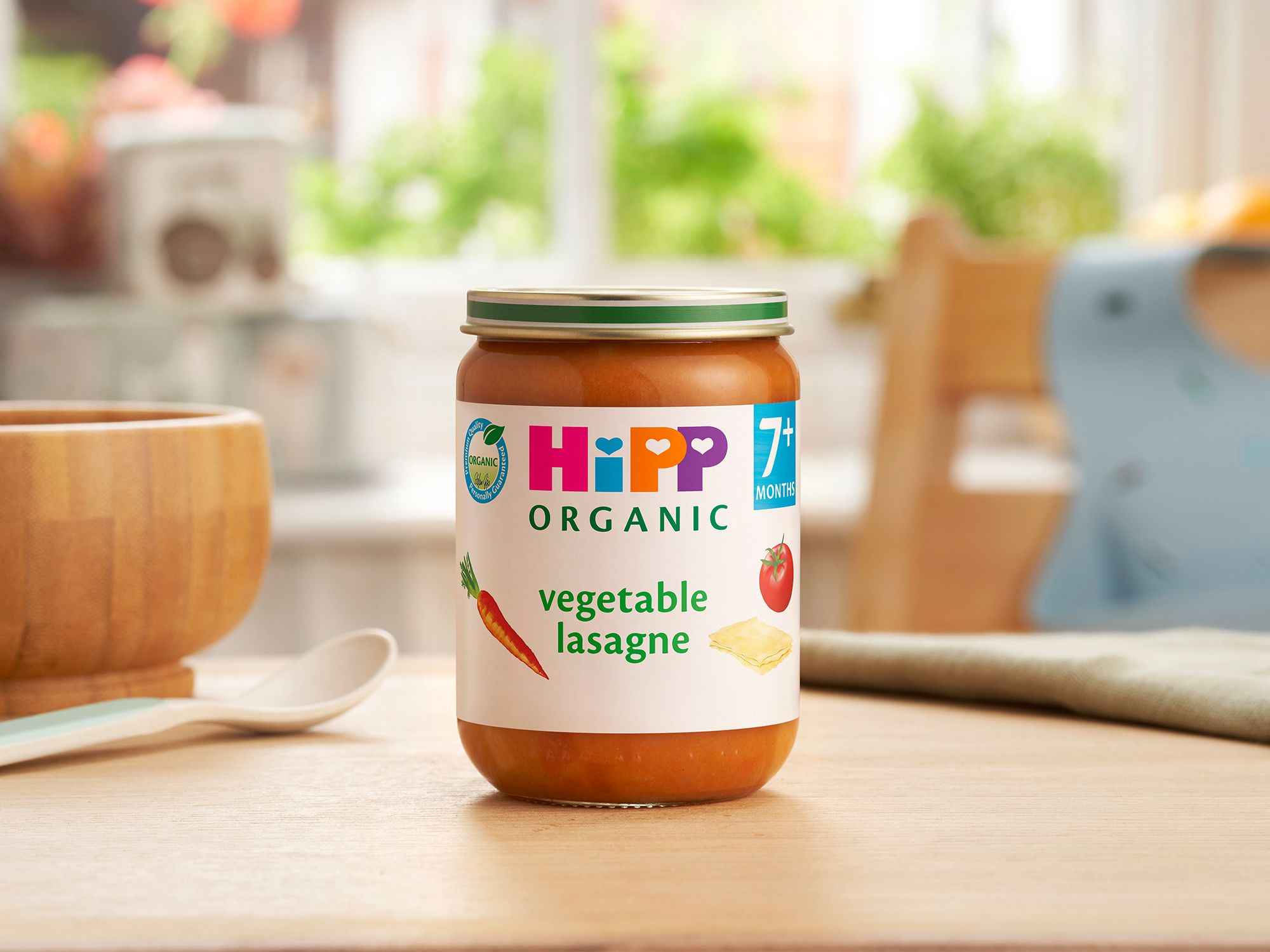 HiPP Organic Vegetable Lasagne on a dining table next to a bowl and spoon