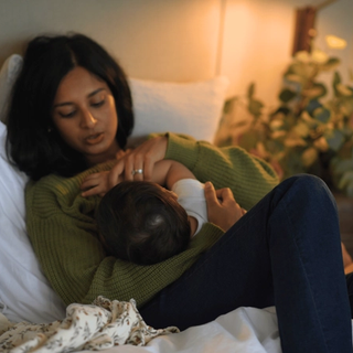 Mum breastfeeding baby in bed