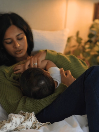 Mum breastfeeding baby in bed