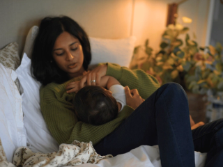 Mum breastfeeding baby in bed