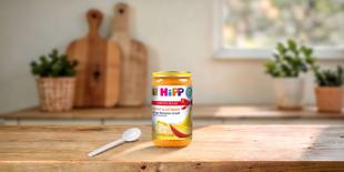 HiPP Bio Mango-Bananen-Grieß 250g Glas auf Holztisch mit Löffel in heller, gemütlicher Küche
