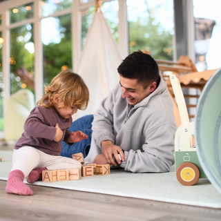 Dad playing with lettered blocks with his toddler