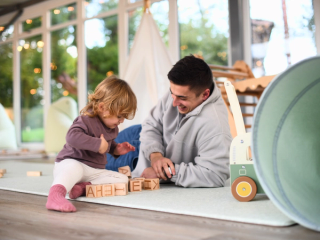 Dad playing with lettered blocks with his toddler