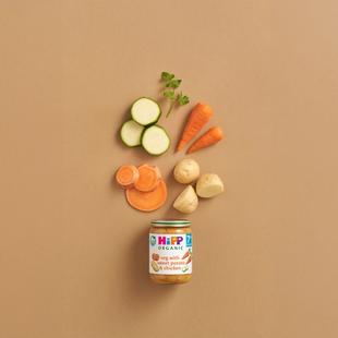 HiPP Organic veg with sweet potato & chicken jar with fresh veg ingredients on a neutral background