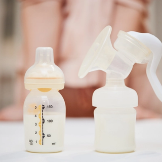 Bottle full of follow on milk and breast pump on a table