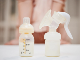 Bottle full of follow on milk and breast pump on a table