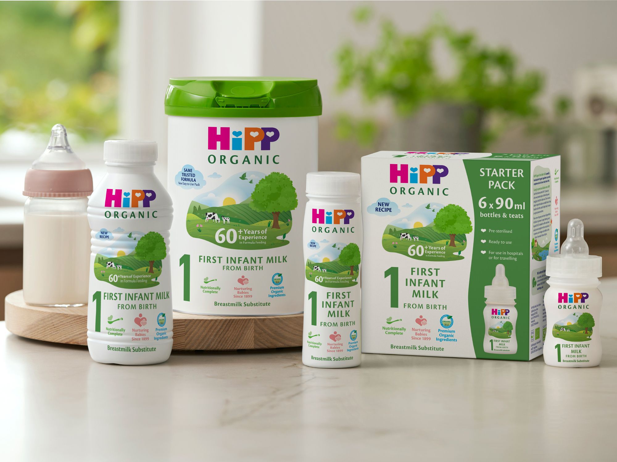HiPP Organic first infant milk ready to feed starter pack with 6 x 90ml bottles and teats arranged on a kitchen worktop
