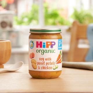 HiPP Organic Veg With Sweet Potato & Chicken Jar on a dining table next to a bowl and spoon