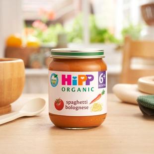 HiPP Organic Spaghetti Bolognese 6 months+ on a dining table next to a bowl and spoon