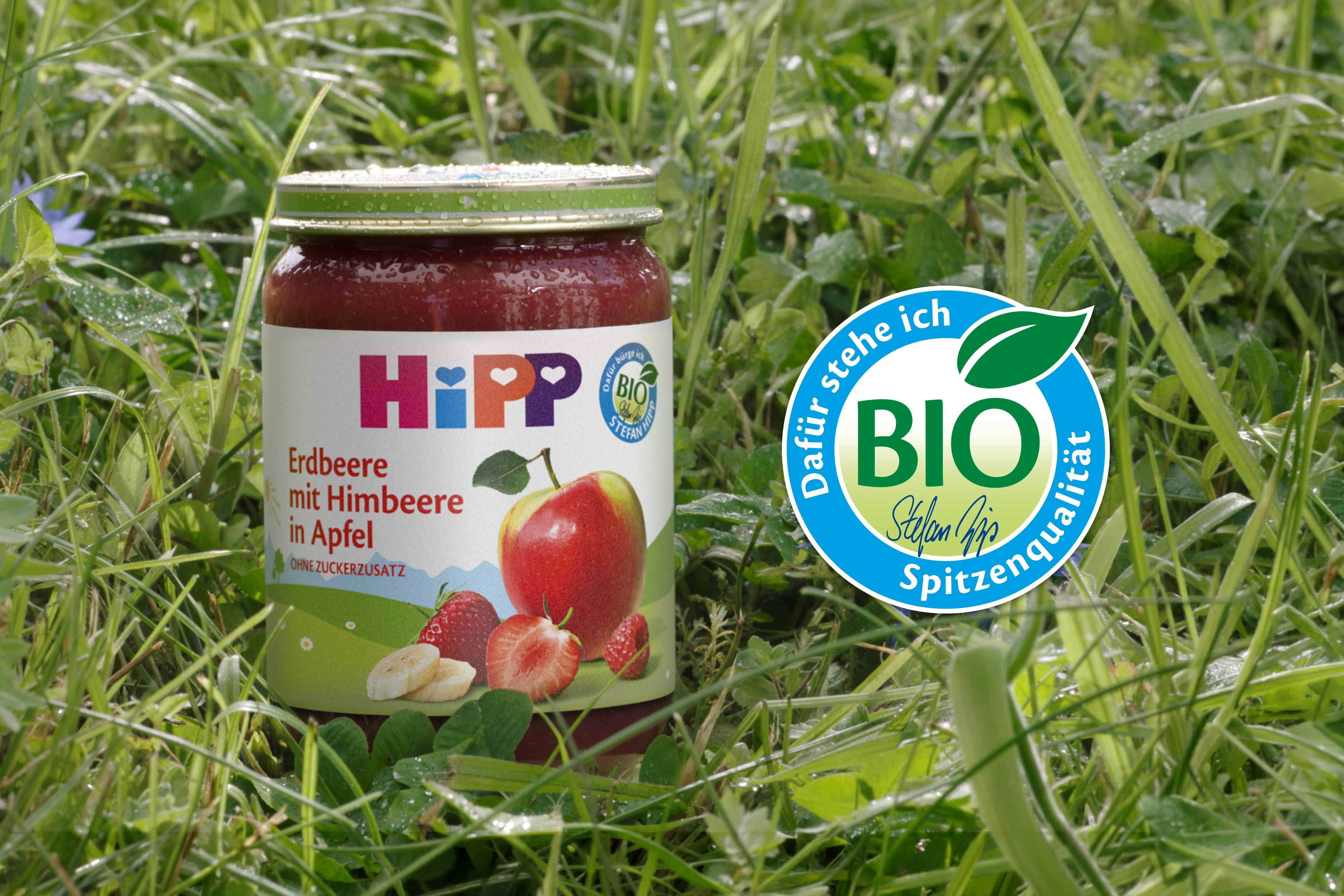HiPP Gläschen steht im Gras, daneben Bio Siegel
