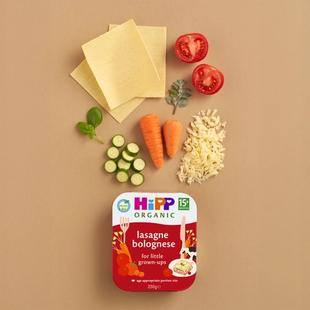 HiPP Organic Lasagne Bolognese toddler tray meal with pasta sheets, tomatoes, carrots, courgette, herbs and cheese on a neutral background