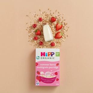HiPP Organic Summer Berry Multigrain Porridge box with milk, oats, strawberries and raspberries on a neutral background