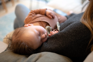 Baby sleeping in mother's arms