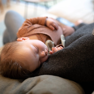baby sleeping in mother's arms.